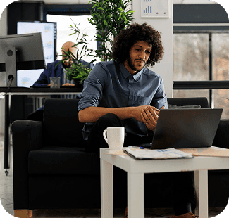 Young man working on laptop in modern office environment.